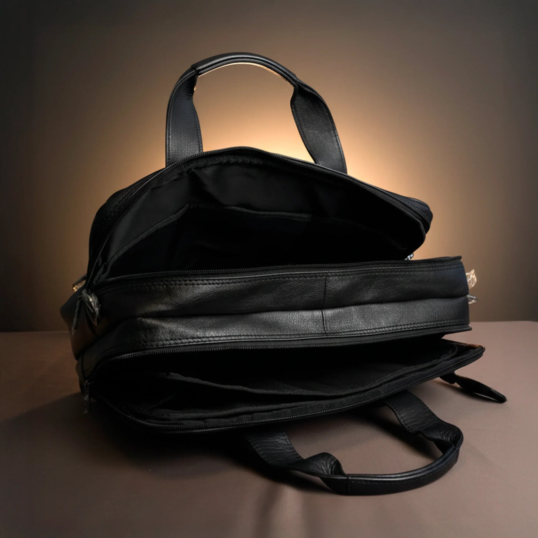 black leather briefcase with open compartments on brown surface under warm light